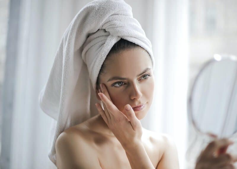 Kobieta w łazience podczas pielęgnacji twarzy. Naturalna pielęgnacji cery trądzikowej.